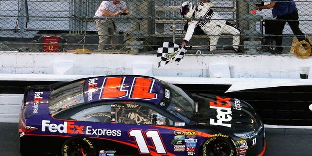 Danny Hamlin picks up the checkered flag after winning the Daytona 500 at Daytona International Speedway in Daytona Beach, Fla., on Sunday, Feb. 21, 2016. (Joe Burbank/Orlando Sentinel/TNS via Getty Images)