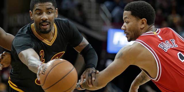 Cleveland Cavaliers' Kyrie Irving, left, passes against Chicago Bulls' Derrick Rose in the second half of an NBA basketball game Thursday, Feb. 18, 2016, in Cleveland.