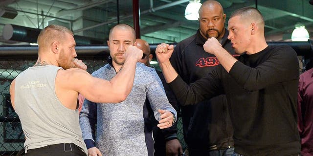 TORRANCE, CA - FEBRUARY 24: UFC featherweight champion Conor McGregor (L) and lightweight contender Nate Diaz (R) are held apart by Dave Sholler (2nd L), UFC vice president of public relations, after a news conference at UFC Gym February 24, 2016, in Torrance, California. (Photo by Kevork Djansezian/Getty Images)