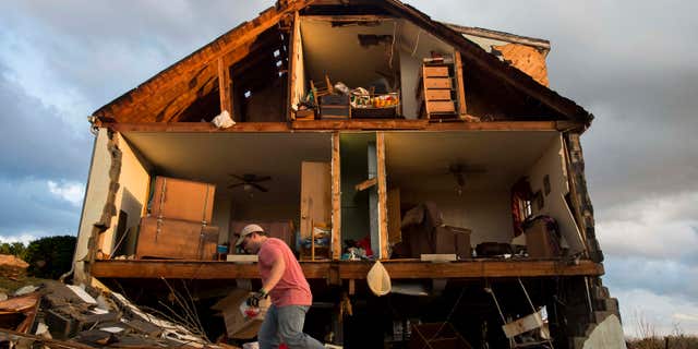 Nick Mobley helps clean up a house owned by a family friend, Wednesday, Feb. 24, 2016, after a storm hit Appomattox County, Va.