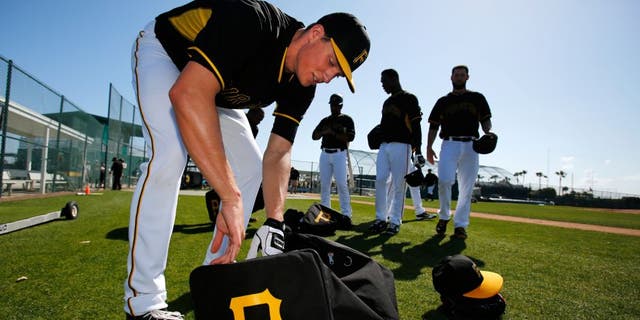 Pittsburgh Pirates pitcher Tyler Glasnow gathers his equipment after taking part in bunting practice during a spring training baseball workout in Bradenton, Fla., Sunday, Feb. 22, 2015. (AP Photo/Gene J. Puskar)