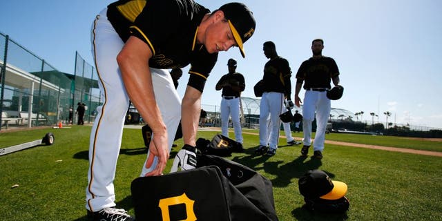 Pittsburgh Pirates pitcher Tyler Glasnow gathers his equipment after taking part in bunting practice during a spring training baseball workout in Bradenton, Fla., Sunday, Feb. 22, 2015. (AP Photo/Gene J. Puskar)