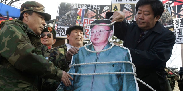 Feb. 25: A South Korean conservative coils a rope around an image of North Korean leader Kim Jong Il during a rally against Kim's rule and to show support for the uprising in the Middle East countries, in Seoul, South Korea.