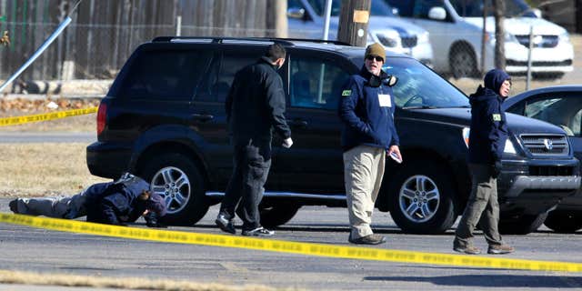Feb. 26, 2016: FBI agents search the parking lot at Excel Industries, the scene of Thursday's shooting, in Hesston, Kan.