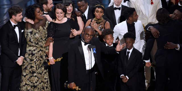 Barry Jenkins, foreground center, and the cast accept the award for best picture for "Moonlight" at the Oscars on Sunday, Feb. 26, 2017, at the Dolby Theatre in Los Angeles.