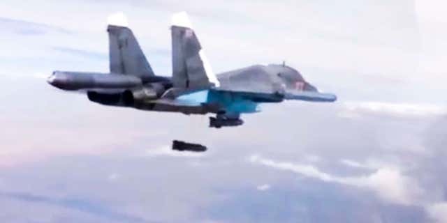 FILE - In this Dec. 9, 2015 file photo made from video footage provided by the Russian Defense Ministry, a Russian Su-34 bomber drops bombs on a target.