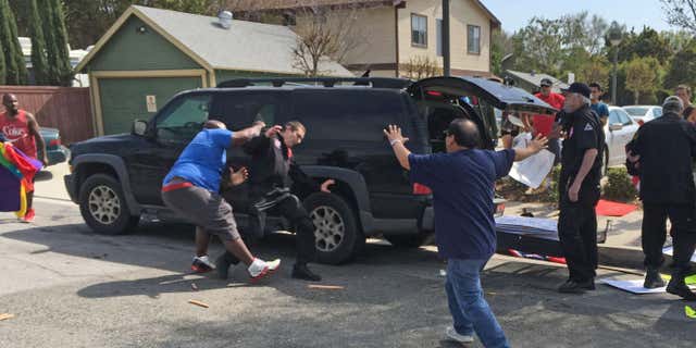 Feb. 27, 2016: This photo provided by the Center for the Study of Hate & Extremism shows, a counter-protester, second from left, and a Ku Klux Klansman, center, scuffling as members of the KKK tried to start an anti-immigrant rally at Pearson Park in Anaheim.