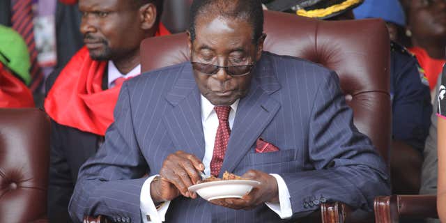 FEb. 27, 2016: Zimbabwean President Robert Mugabe eats his cake during celebrations to mark his 92nd Birthday celebrations in Masvingo about 300 kilometres south of Harare,.