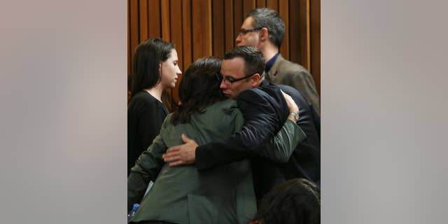Oscar Pistorius greets and hugs family and friends as the prosecution wraps up its case in Pretoria, South Africa, Tuesday, March 25, 2014. Pistorius is charged with the Valentines Day 2013 shooting death of his girlfriend Reeva Steenkamp. (AP Photo/Esa Alexander, Pool)