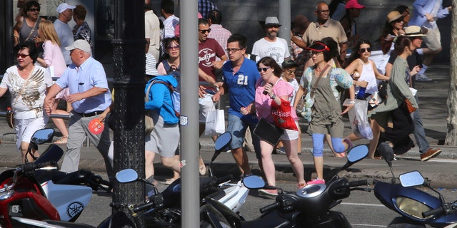 People flee the scene in Barcelona, Spain, Thursday, Aug. 17, 2017 after a white van jumped the sidewalk in the historic Las Ramblas district, crashing into a summer crowd of residents and tourists and injuring several people, police said. (AP Photo/Oriol Duran)