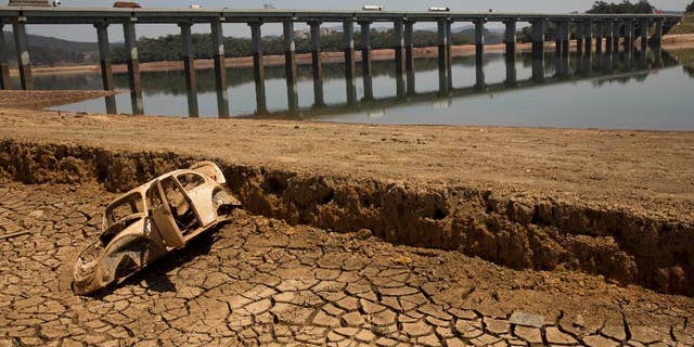 FILE - In this Oct. 10, 2014 file photo, the frame of a car sits on the cracked earth at the bottom of the Atibainha dam, part of the Cantareira System responsible for providing water to the Sao Paulo metropolitan area, in Nazare Paulista, Brazil. Halfway through the rainy season, the key reservoir for the hemisphere's largest city, the Cantareira water system, holds just 6 percent of its capacity, and experts warned Friday, Jan. 16, 2015 that authorities must take urgent steps to prevent the worst drought here in more than 80 years from drying it out. (AP Photo/Andre Penner, File)