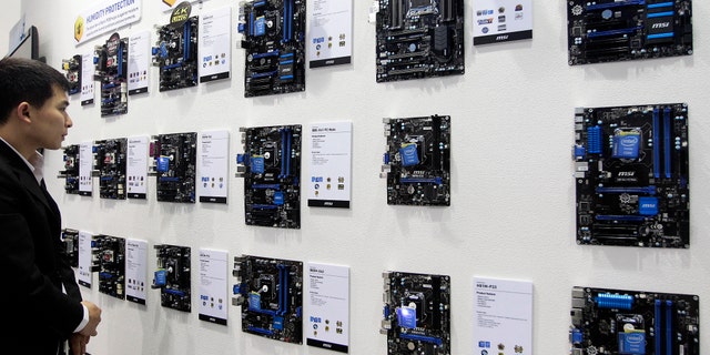 June 4, 2013: A visitor looks at motherboards at the MSI booth at the 2013 Computex exhibition. The blurring distinction between humans a technology has remained a mainstay of science fiction, but appears to be steadily becoming more of a reality.