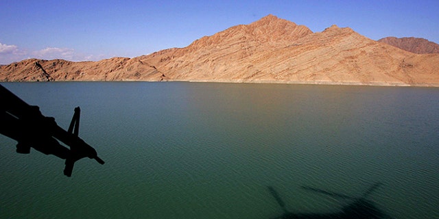 In this Jan. 11, 2007, file photo, a shadow of a British Royal Air Force Chinook helicopter is seen on the Kajaki Dam reservoir as it carries the supplies for the forward operating base at Kajaki, in southern Afghanistan.