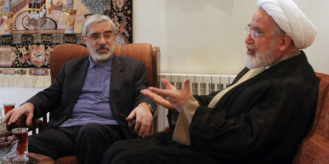 In this Saturday, Oct. 10, 2009, file photo, leaders of Iranian opposition, Mahdi Karroubi, right, and Mir Hossein Mousavi talk in Tehran, Iran.