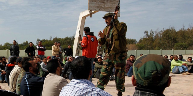March 3: A former Libyan army soldier shows new Libyan rebel recruits how to use the AK-47, during a training session after signing up with the forces against Libyan leader Muammar al-Qaddafi at a training base in Benghazi, eastern Libya.