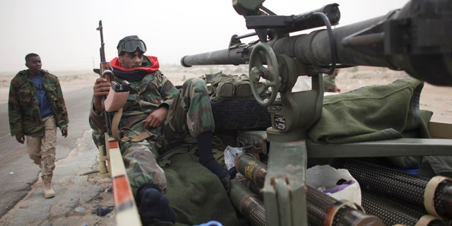 March 4: A defected Libyan soldier sits with his weapons on the outskirts of the eastern town of Brega, Libya.