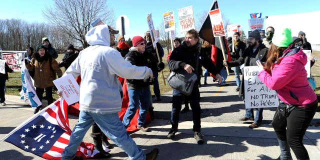 March 4, 2017: Trump supporters, left, and protestors, right, briefly push and shove each other after a woman was allegedly hit and a sign thrown on the ground during a rally in support of President Donald Trump at Freedom Hill County Park in Sterling Heights, Mich.