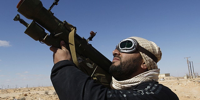 March 6: An rebel against Libyan leader Muammar Qaddafi holds his anti-aircraft missile as he looks to the sky, in the oil town of Ras Lanouf, eastern Libya.
