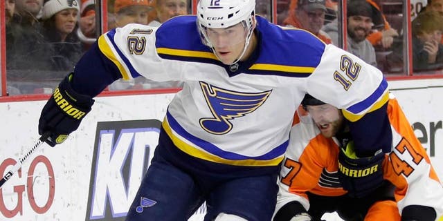 St. Louis Blues' Jori Lehtera (12), of Finland, keeps Philadelphia Flyers' Andrew MacDonald (47) away from the puck during the first period of an NHL hockey game, Thursday, March 5, 2015, in Philadelphia. (AP Photo/Matt Slocum)