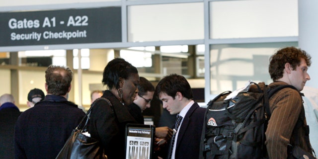 In this March 8, 2010 photo, travelers wait in line prior to entering a security checkpoint at Logan International Airport in Boston. (AP)