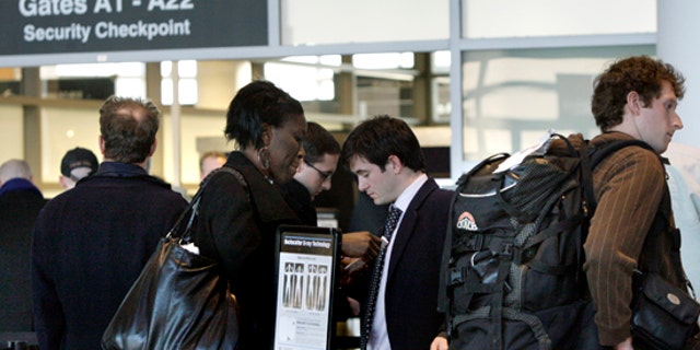 In this March 8, 2010 photo, travelers wait in line prior to entering a security checkpoint at Logan International Airport in Boston. (AP)