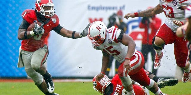 Jan 1, 2014; Jacksonville, FL, USA; Georgia Bulldogs tailback Todd Gurley (3) runs the ball against Nebraska Cornhuskers linebacker Michael Rose (15) as he runs for a first down in the fourth quarter of their game at EverBank Field. The Nebraska Cornhuskers beat the Georgia Bulldogs 24-19. Mandatory Credit: Phil Sears-USA TODAY Sports