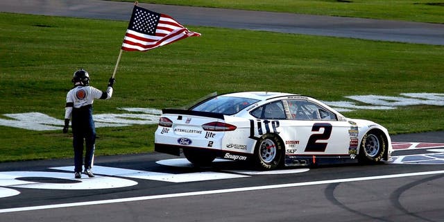 LAS VEGAS, NV - MARCH 06: Brad Keselowski, driver of the #2 Miller Lite Ford, celebrates with the American Flag after winning the NASCAR Sprint Cup Series Kobalt 400 at Las Vegas Motor Speedway on March 6, 2016 in Las Vegas, Nevada. (Photo by Todd Warshaw/Getty Images)