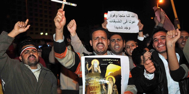 March 8: Egyptian Copts carry a cross, a picture showing saints along a banner in Arabic that reads: "God is our shelter and strength, he will help us in hard times" during a protest in downtown Cairo, Egypt.