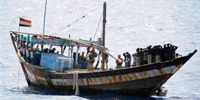 Feb. 16: In this image made available by the Ministry of Defence in London, a naval boarding party from HMS Cornwall guard Somali pirates after their dhow was boarded in the Indian Ocean.