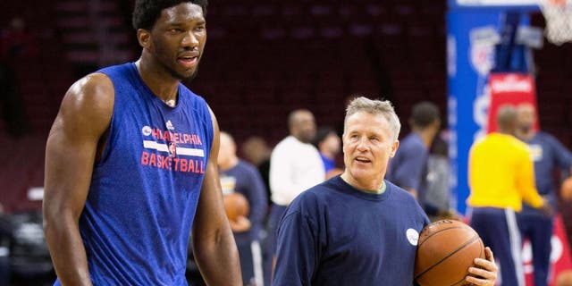 Feb 20, 2015; Philadelphia, PA, USA; Philadelphia 76ers head coach Brett Brown (left) walks with center Joel Embiid (21) after running him threw drills prior to a game against the Indiana Pacers at Wells Fargo Center. Mandatory Credit: Bill Streicher-USA TODAY Sports
