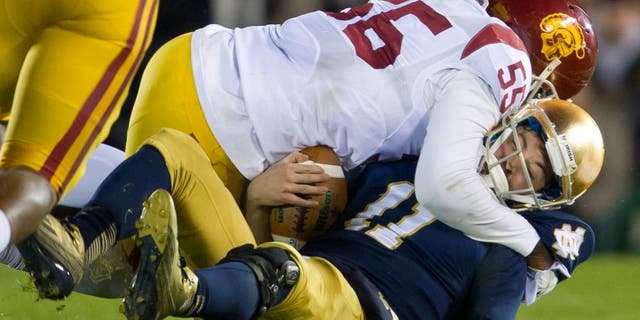Oct 19, 2013; South Bend, IN, USA; Notre Dame Fighting Irish quarterback Tommy Rees (11) is sacked by USC Trojans linebacker Lamar Dawson (55) in the third quarter at Notre Dame Stadium. Notre Dame won 14-10. Mandatory Credit: Matt Cashore-USA TODAY Sports