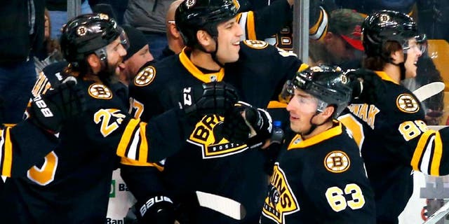 Mar 8, 2015; Boston, MA, USA; Boston Bruins left wing Brad Marchand (63) is congratulated at the bench by Boston Bruins center Maxime Talbot (25) and left wing Milan Lucic (17) after scoring against the Detroit Red Wings during the first period at TD Garden. Mandatory Credit: Winslow Townson-USA TODAY Sports