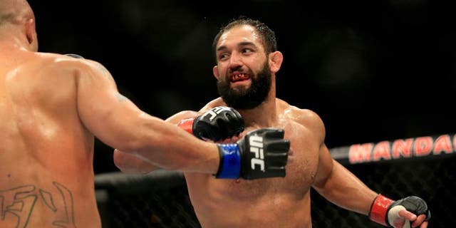LAS VEGAS, NV - DECEMBER 06: Johny Hendricks punches Robbie Lawler in their welterweight title fight during the UFC 181 event at the Mandalay Bay Events Center on December 6, 2014 in Las Vegas, Nevada. (Photo by Alex Trautwig/Getty Images)