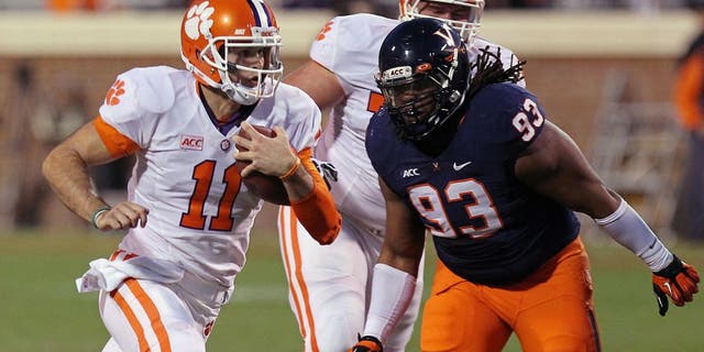 Nov 2, 2013; Charlottesville, VA, USA; Clemson Tigers quarterback Chad Kelly (11) runs with the ball past Virginia Cavaliers defensive tackle Donte Wilkins (93) to score a touchdown in the fourth quarter at Scott Stadium. The Tigers won 59-10. Mandatory Credit: Geoff Burke-USA TODAY Sports