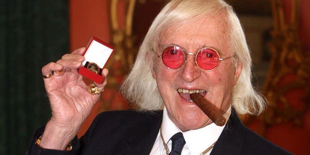 March 25, 2008: This file photo shows Jimmy Savile showing a medal in London.