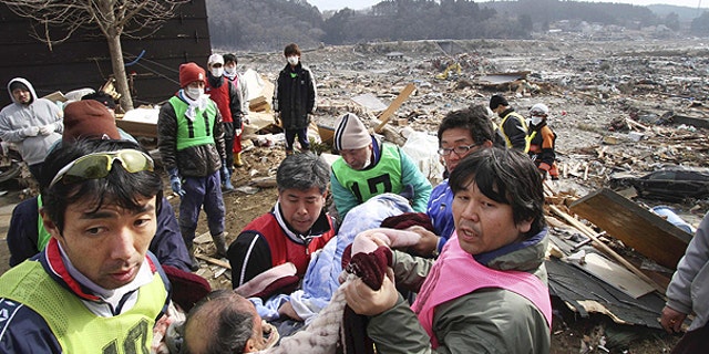 March 14: Rescue workers carry an elderly man found alive by tsunami survivors buried under rubble along a slope of a hill in n Minami Sanrikucho in Iwate Prefecture three days after a powerful earthquake-triggered tsunami hit the country's east coast.