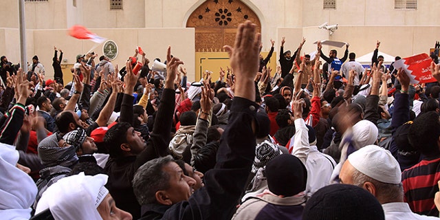 March 15: Anti-government protesters gesture in front of the Saudi embassy in Manama, Bahrain.