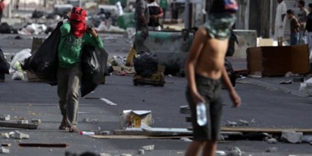 March 16: Shiite Bahraini youths haul debris into the streets of the western village of Malkiya, Bahrain, in preparation for government-supporting forces they anticipate will roll into their Shiite Muslim village southwest of the capital of Manama.