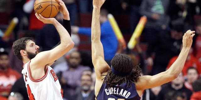 Chicago Bulls forward Nikola Mirotic, left, shoots over Indiana Pacers forward Chris Copeland during the second half of an NBA basketball game in Chicago on Wednesday, March 18, 2015. The Bulls won 103-86. (AP Photo/Nam Y. Huh)