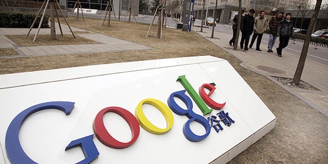 In a Monday March 22, 2010, file photo men walk past the Google China headquarters in Beijing, China.