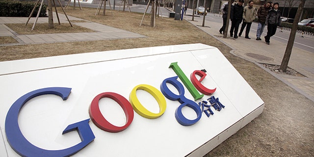 In a Monday March 22, 2010, file photo men walk past the Google China headquarters in Beijing, China.