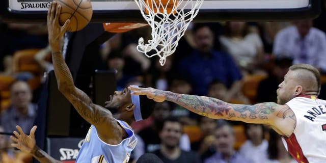 Denver Nuggets' Will Barton, left, attempts a shot against Miami Heat's Chris Andersen, right during the first half of an NBA basketball game, Friday, March 20, 2015, in Miami. (AP Photo/Lynne Sladky)