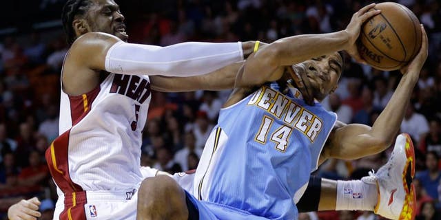 Miami Heat's Henry Walker, left, forces a jump ball as he defends Denver Nuggets' Gary Harris (14) during the second half of an NBA basketball game, Friday, March 20, 2015, in Miami. The Heat defeated the Nuggets 108-91. (AP Photo/Lynne Sladky)