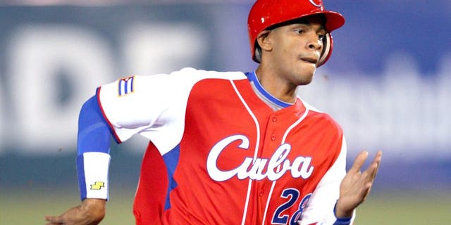 MEXICO CITY - MARCH 10: Second baseman Hector Olivera #28 of Cuba scores a run in the top of the seventh inning on a two-out double by Michel Enriquez #12 of Cuba that cuts the Australia lead to 4-3 during the Pool B, game four against Australia in the first round of the 2009 World Baseball Classic at Foro Sol Stadium in Mexico City, Mexico, Monday March 10, 2009. Cuba defeated Australia 5-4. (Photo by Paul Spinelli/WBCI/MLB Photos via Getty Images)