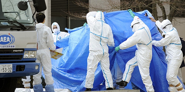 March 25: Workers, who stepped into radiation-contaminated water during Thursday's operation at the Fukushima Dai-ichi nuclear plant, are shielded with tarps before receiving decontamination treatment at a hospital in Fukushima, northeastern Japan.