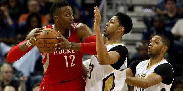 Mar 25, 2015; New Orleans, LA, USA; Houston Rockets center Dwight Howard (12) is defended by New Orleans Pelicans forward Anthony Davis (23) during the second half of a game at the Smoothie King Center. The Rockets defeated the Pelicans 95-93. Mandatory Credit: Derick E. Hingle-USA TODAY Sports