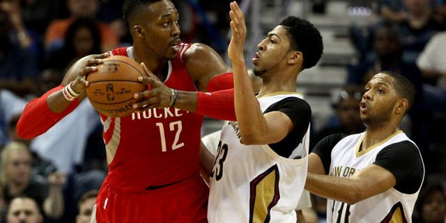 Mar 25, 2015; New Orleans, LA, USA; Houston Rockets center Dwight Howard (12) is defended by New Orleans Pelicans forward Anthony Davis (23) during the second half of a game at the Smoothie King Center. The Rockets defeated the Pelicans 95-93. Mandatory Credit: Derick E. Hingle-USA TODAY Sports