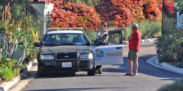 March 24, 2016: A Goleta Police officer stands guard near a home on Greenhill Way in unincorporated county territory between Santa Barbara and Goleta, Calif.