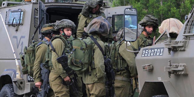 March 26: Israeli soldiers are seen at the Gaza Strip on the border with Israel. The Israeli military says two soldiers have been killed in an exchange of fire with militants who were planting explosives along the security fence in the southern Gaza Strip.