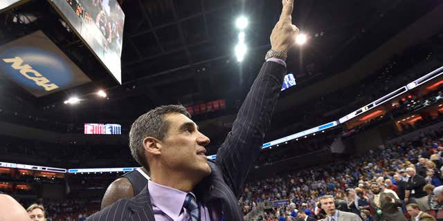 Villanova head coach Jay Wright raises his hand to fans after a regional final men's college basketball game in the NCAA Tournament against Kansas, Saturday, March 26, 2016, in Louisville, Ky.